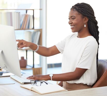 Businesswoman Pointing to Her Computer and Smiling