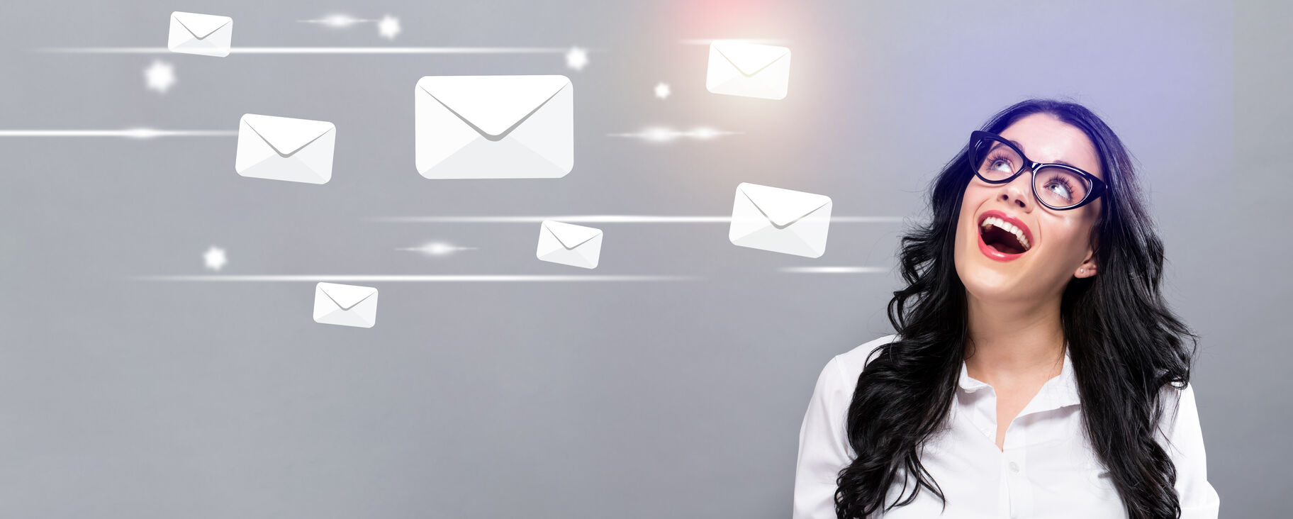 Email Marketing Trends 2023 Happy lady with black glasses smiling up at email envelopes