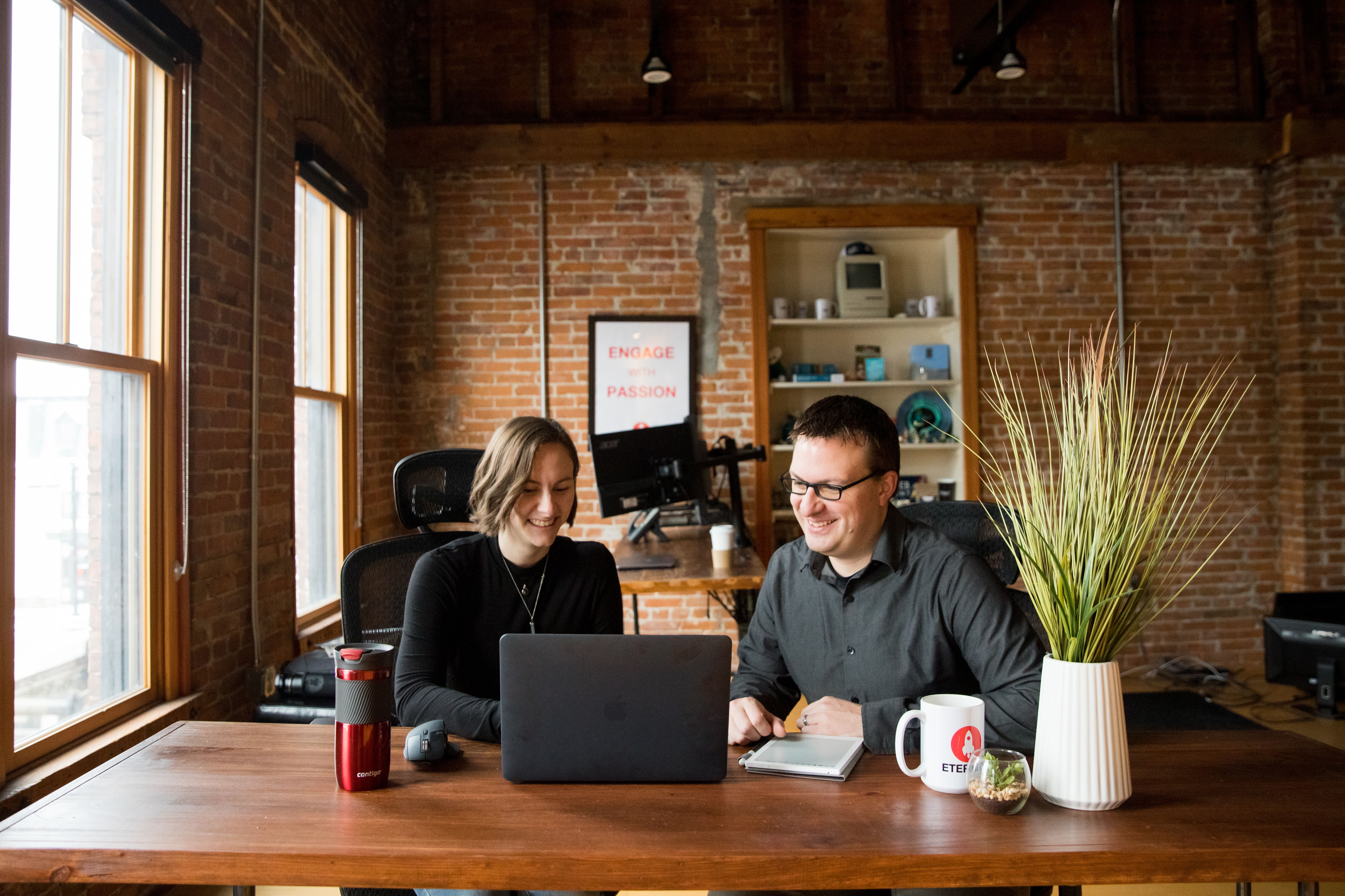 Shawna and Mike working together on a laptop in the Eternity headquarters