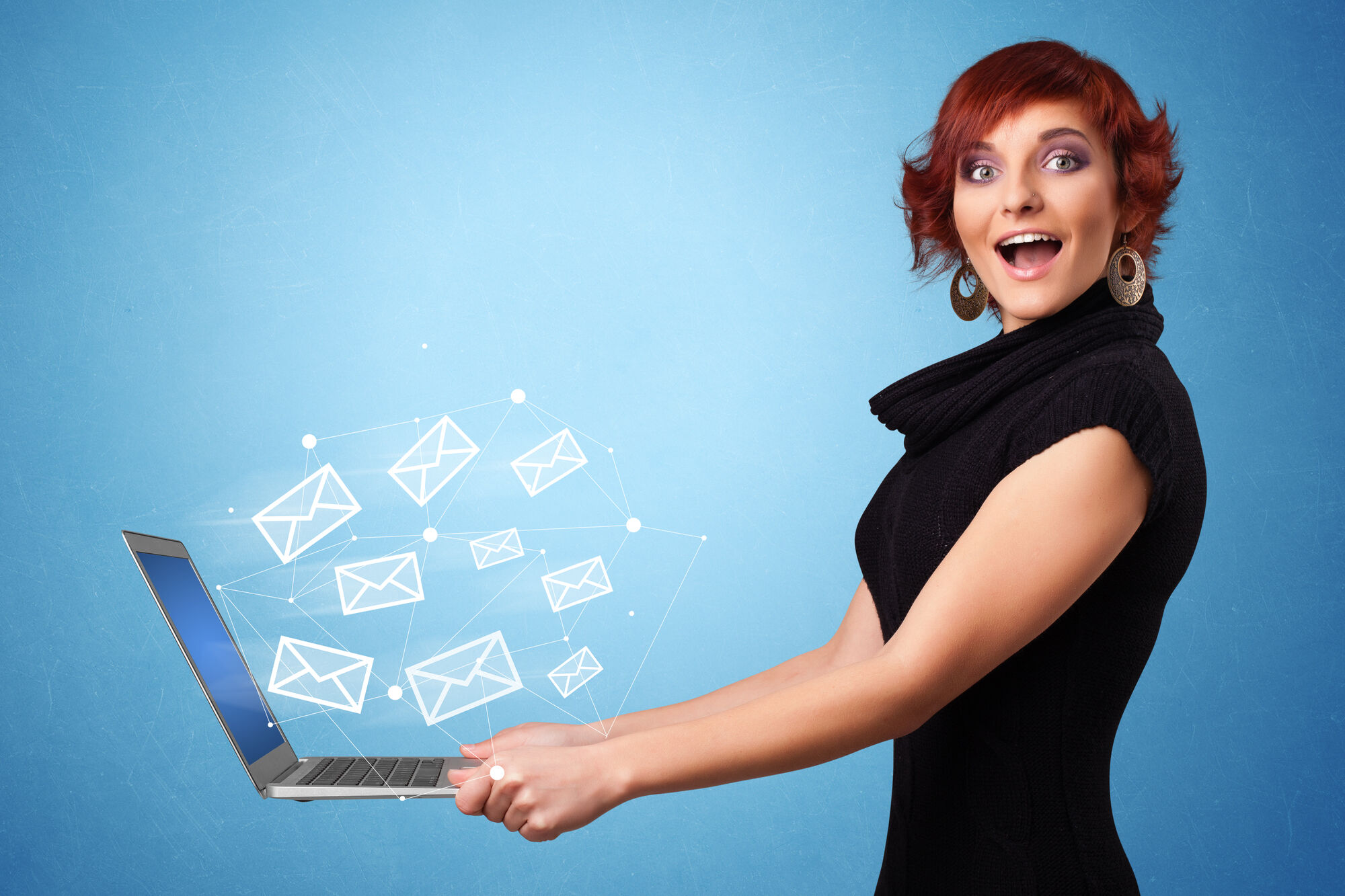 happy woman holding a laptop with email icons floating above it