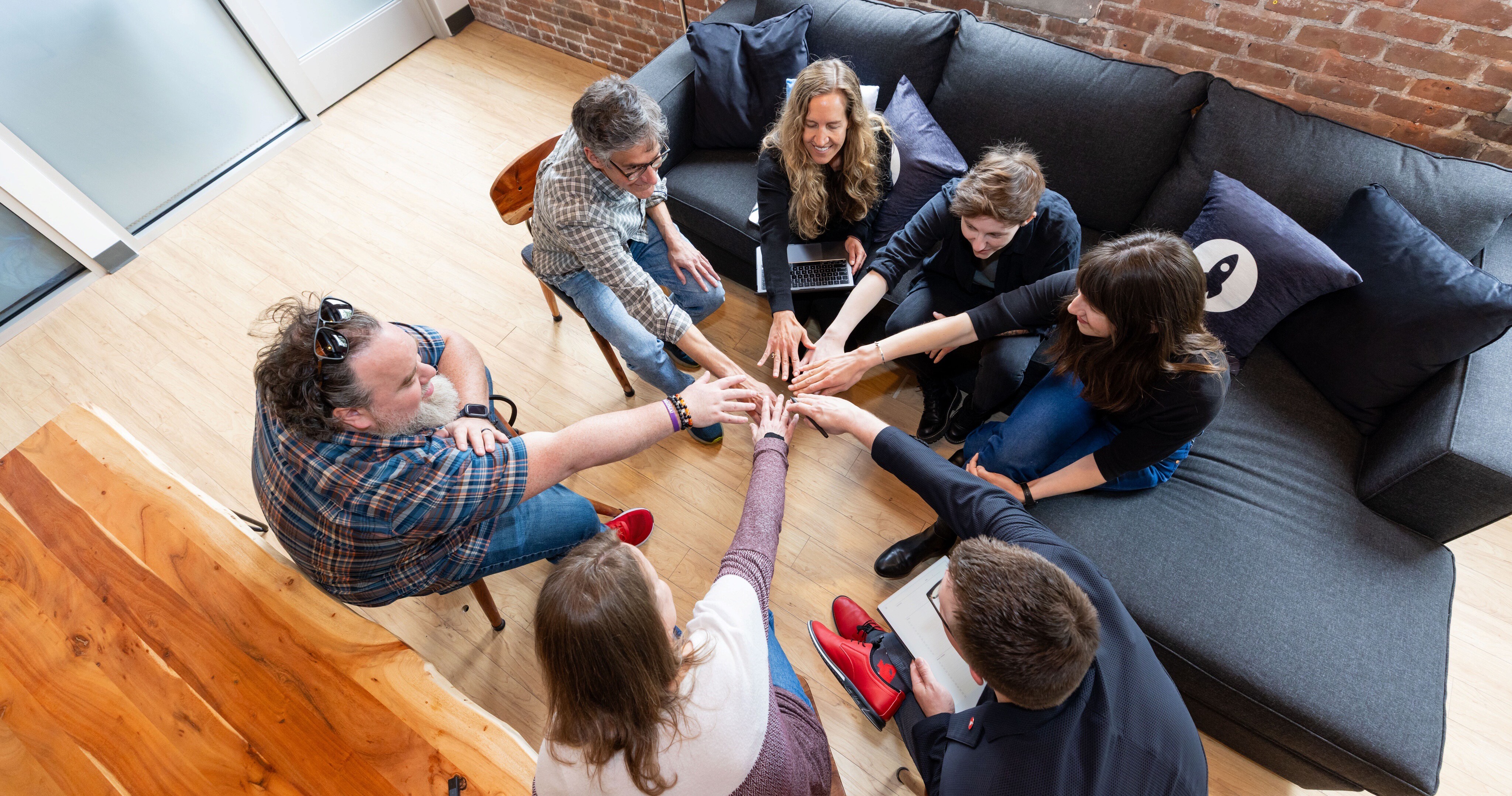 Group of people gathered around a table, engaging in a teamwork activity.