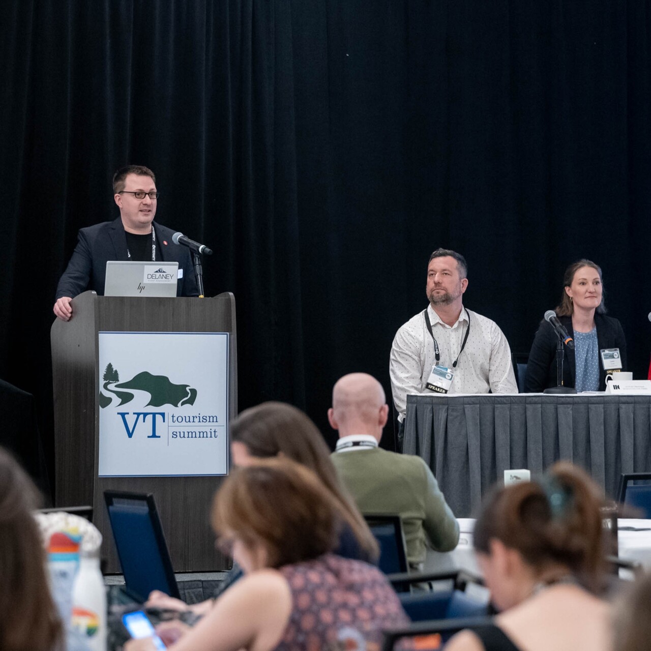 Panel discussion at the VT Tourism Summit with a speaker and audience engaged.