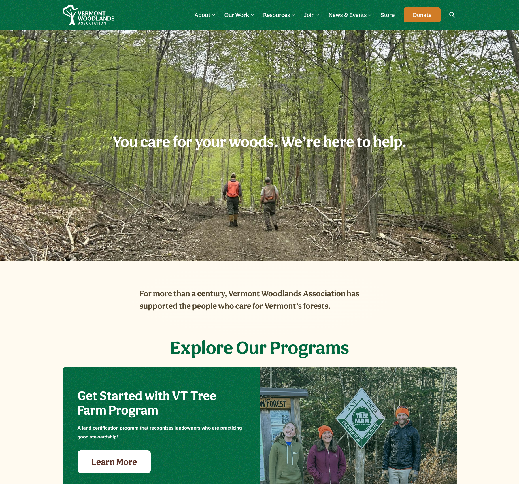 Two people walking on a forest path, promoting Vermont Woodlands Association's work.