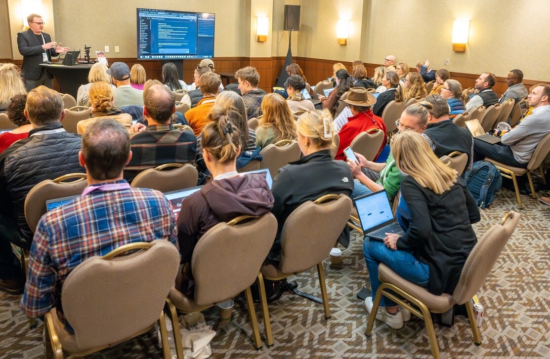 A speaker presenting to an engaged audience in a conference room.