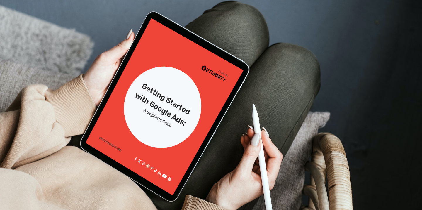 Person holding a tablet displaying "Getting Started with Google Ads: A Beginner's Guide".