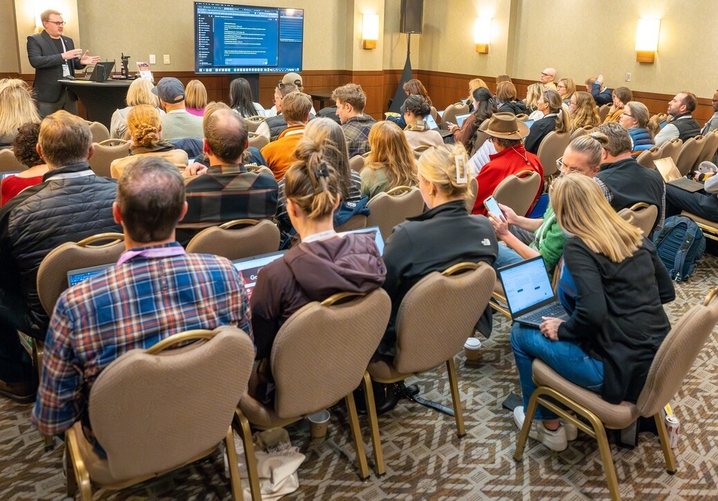 A speaker presenting to an engaged audience in a conference room.