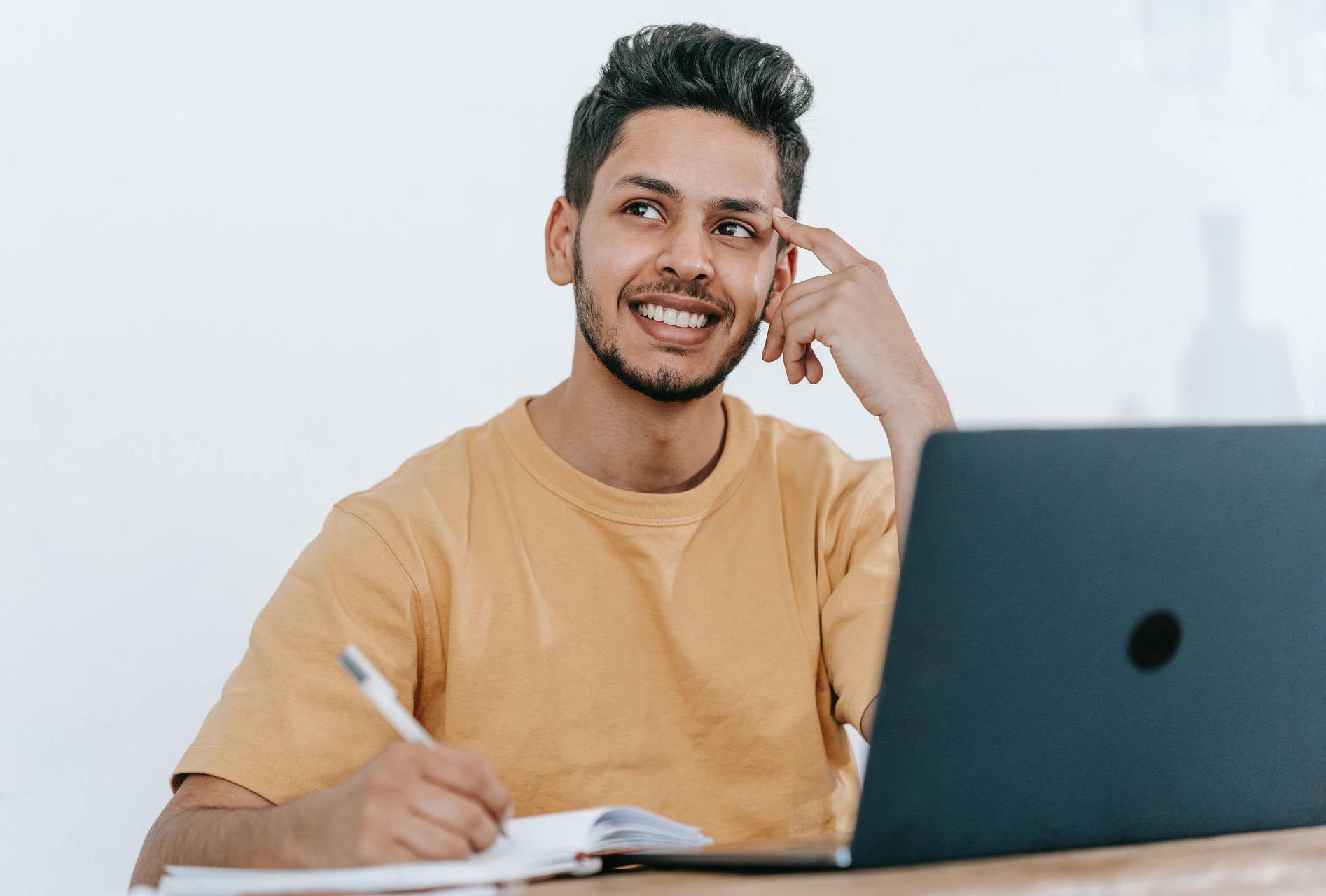 Man Writing on Laptop