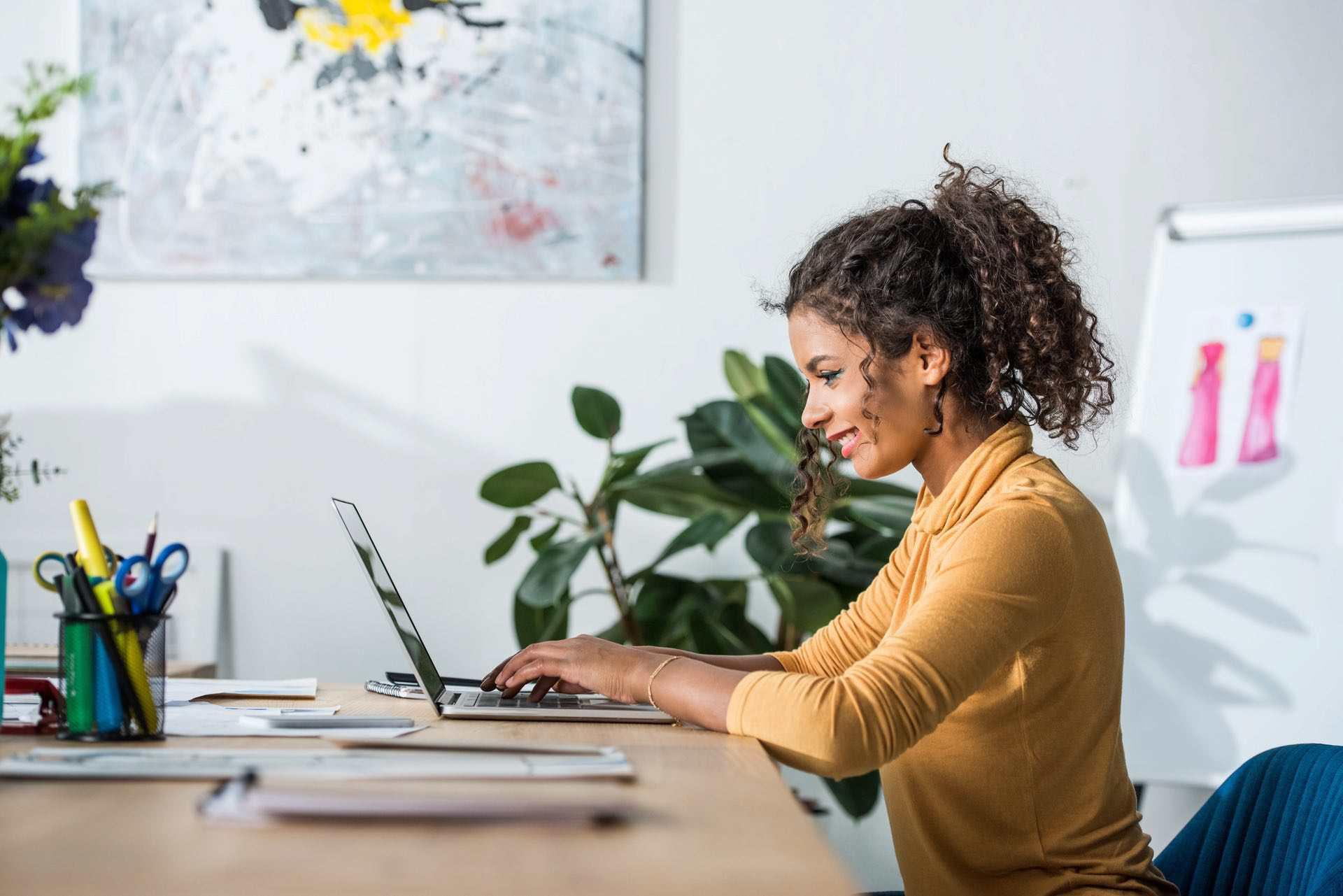 Young black woman smiling using her laptop