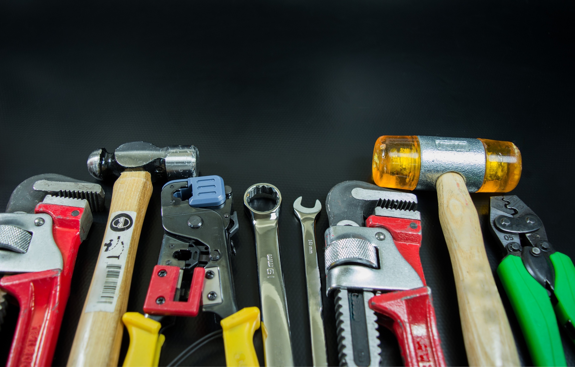 a black background with brightly colored hand tools lined up neatly next to each other