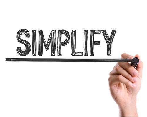 A hand holding a marker writing the word "SIMPLIFY" in bold text