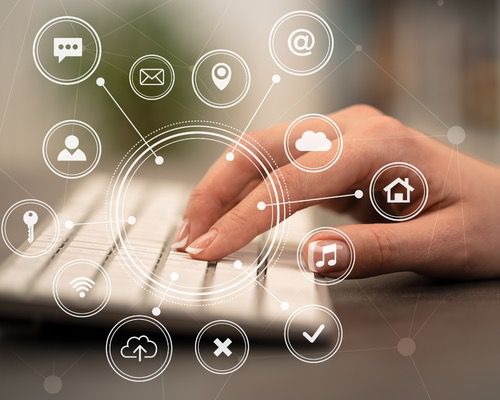 Hand on keyboard with digital icons representing communication and connectivity