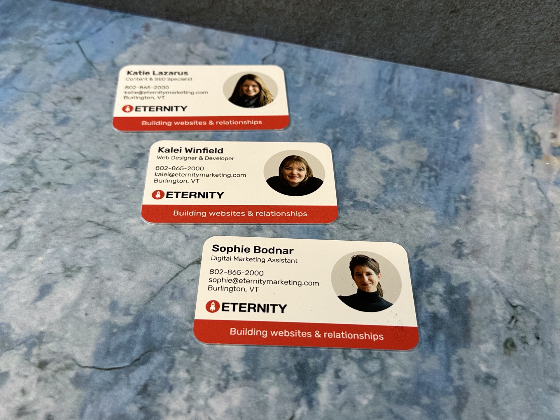 Three business cards for ETERNITY employees with names and roles displayed