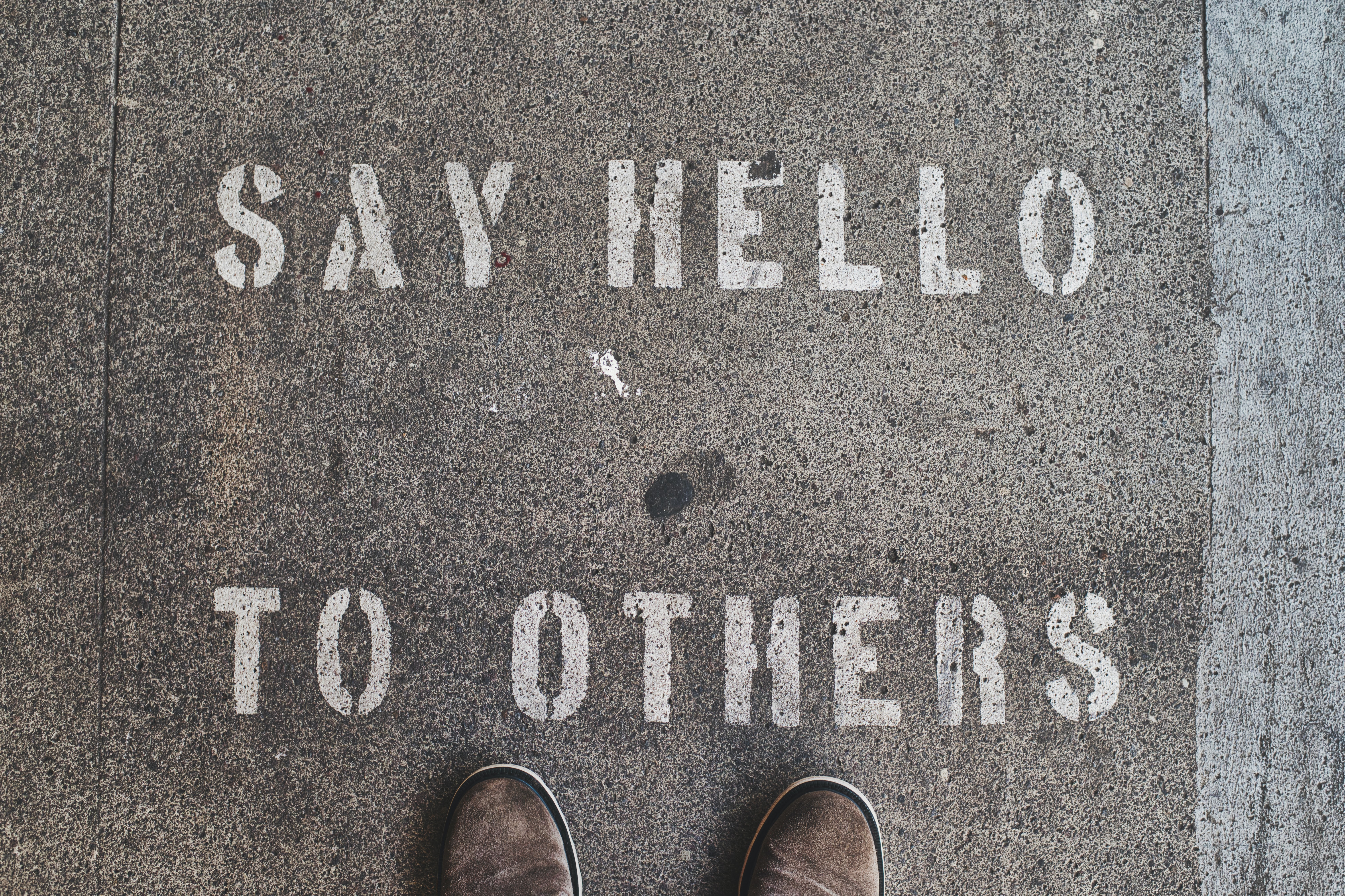 Picture of sidewalk art that says "Say hello to others."