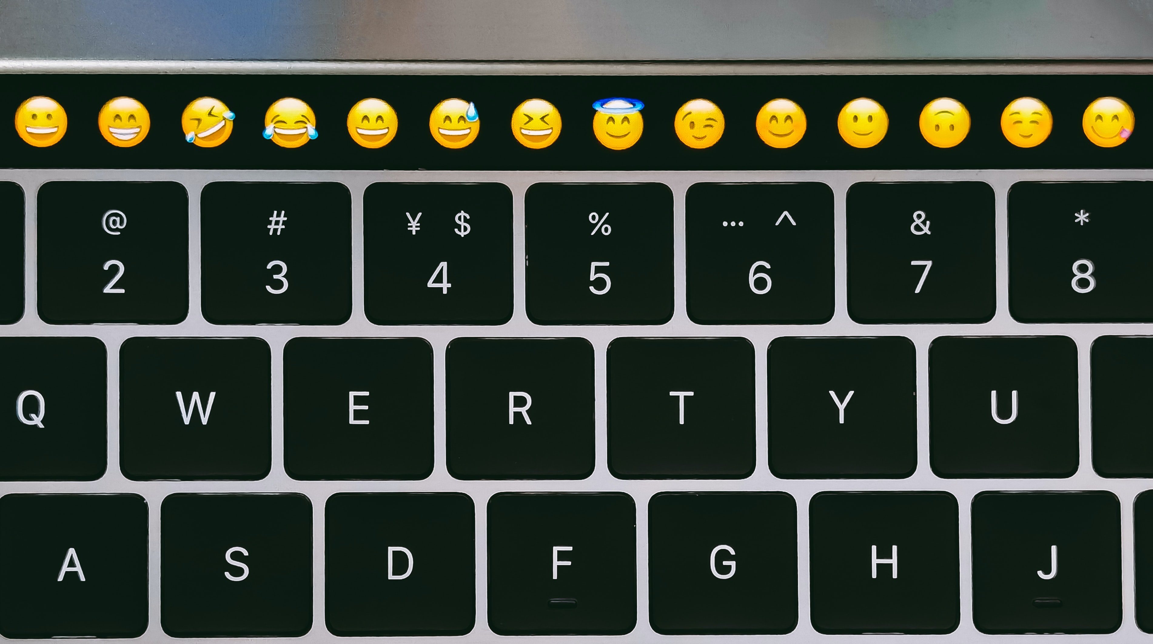 Computer keyboard with a row of emoji keys